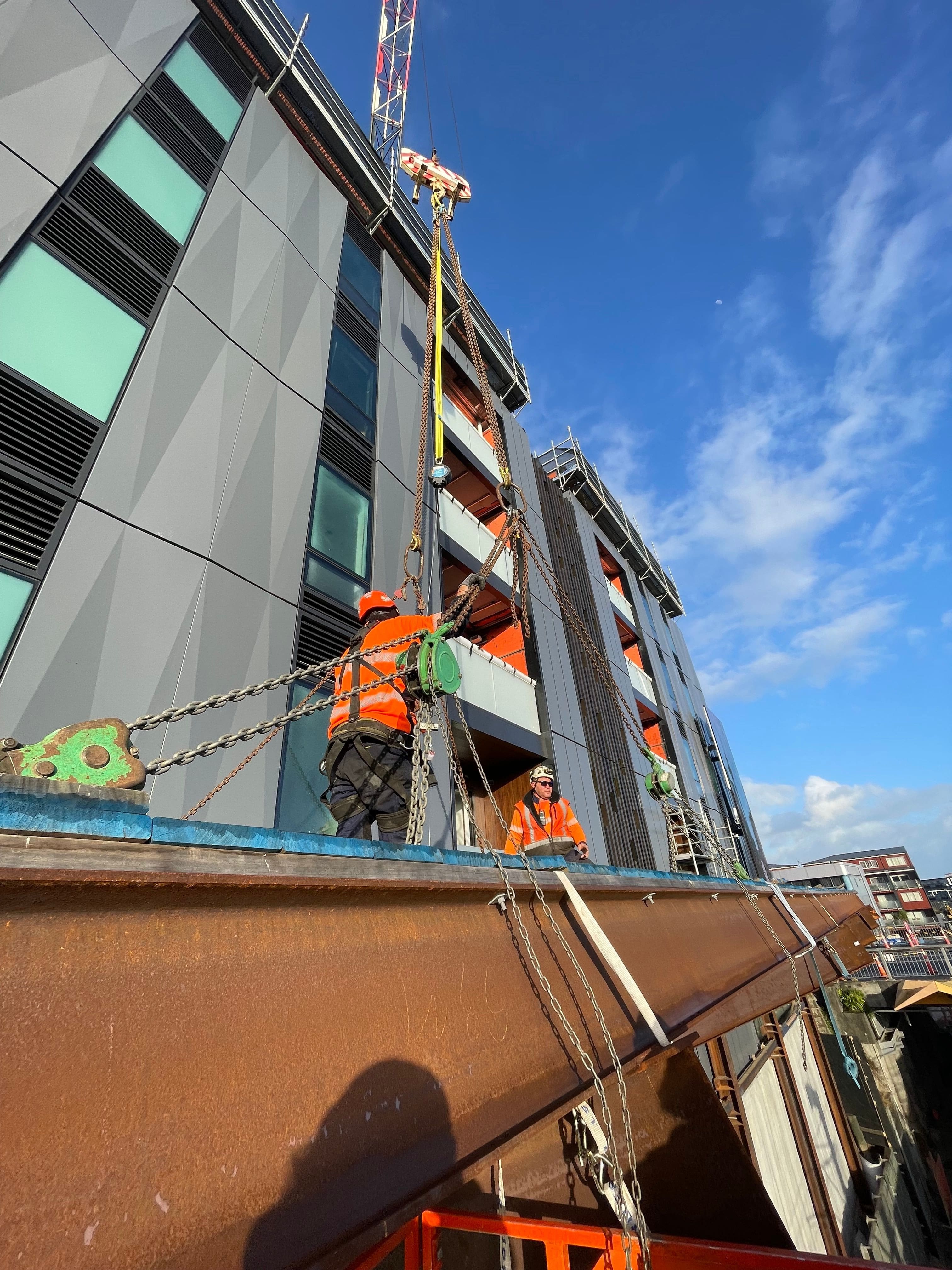 Workers guiding a precast concrete panel into position