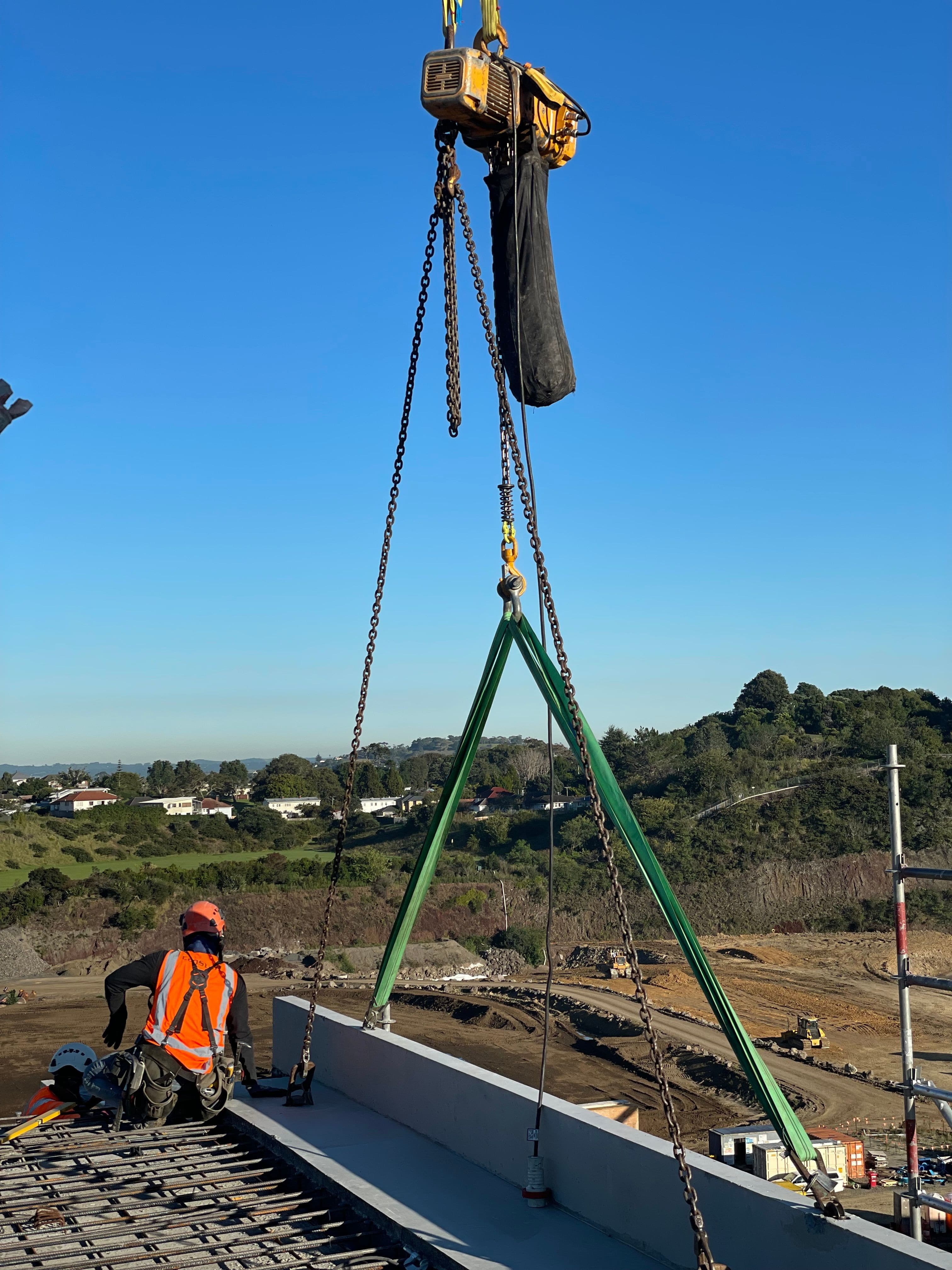 Green rigging spreader bar on construction site